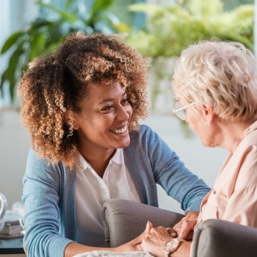 Einfühlsames Gespräch zwischen Betreuerin und Seniorin