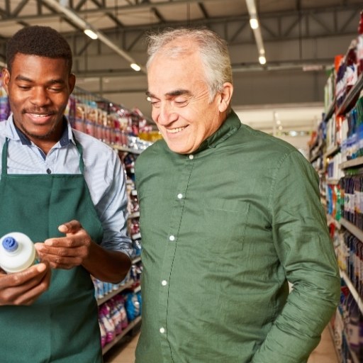 Junger Mann hilft Senior beim Einkauf im Supermarkt
