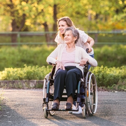 Spaziergang mit Rollstuhl durch eine Parkanlage